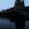 As the light fades at dusk the reflection of the castle at Ogmore appears in the river.